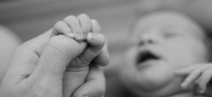 Ein liebevoll gehaltenes Baby sucht Nähe und Geborgenheit bei seiner Mutter – typische Situation im Alltag mit einem High Need Baby, das besonders viel Zuwendung und Aufmerksamkeit braucht.