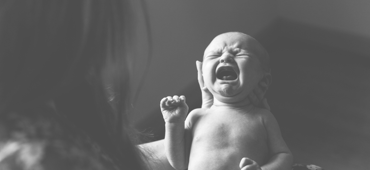 Schreibaby: Ursachen und Unterstützung für Eltern – Ein weinendes Baby wird von seiner Mutter getröstet. Das Bild steht für exzessives Schreien, typische Symptome eines Schreibbabys und zeigt, wie wichtig professionelle Hilfe und individuelle Unterstützung für betroffene Familien sind.
